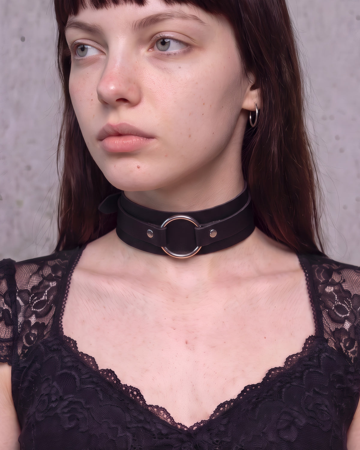 Collier ras-de-cou Romy en cuir vegan noir à anneau argenté, porté de trois-quarts avec un top noir à dentelle