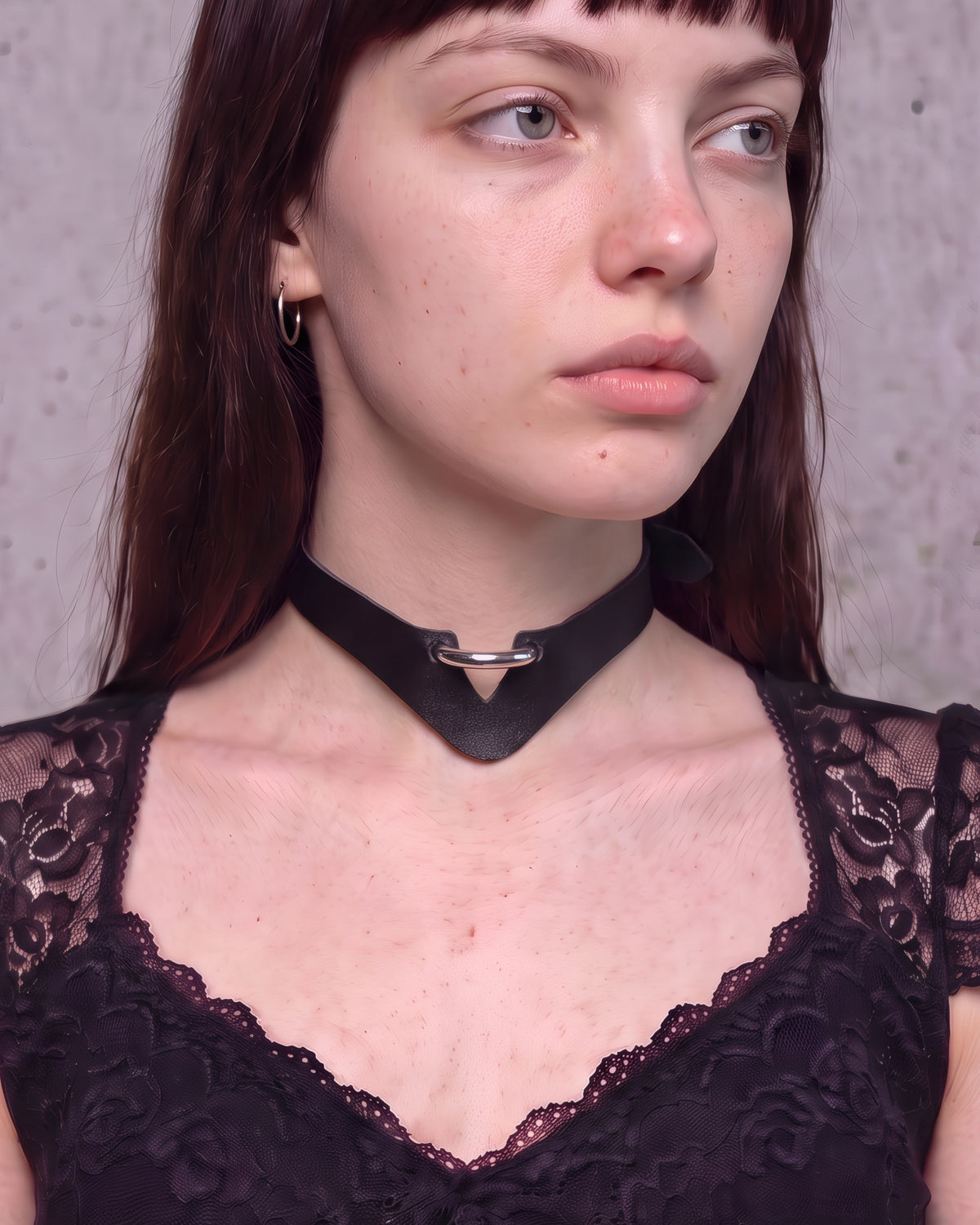 Collier ras-de-cou Mina en cuir vegan noir en V avec demi-anneau argenté, porté de trois-quarts avec un top noir à dentelle