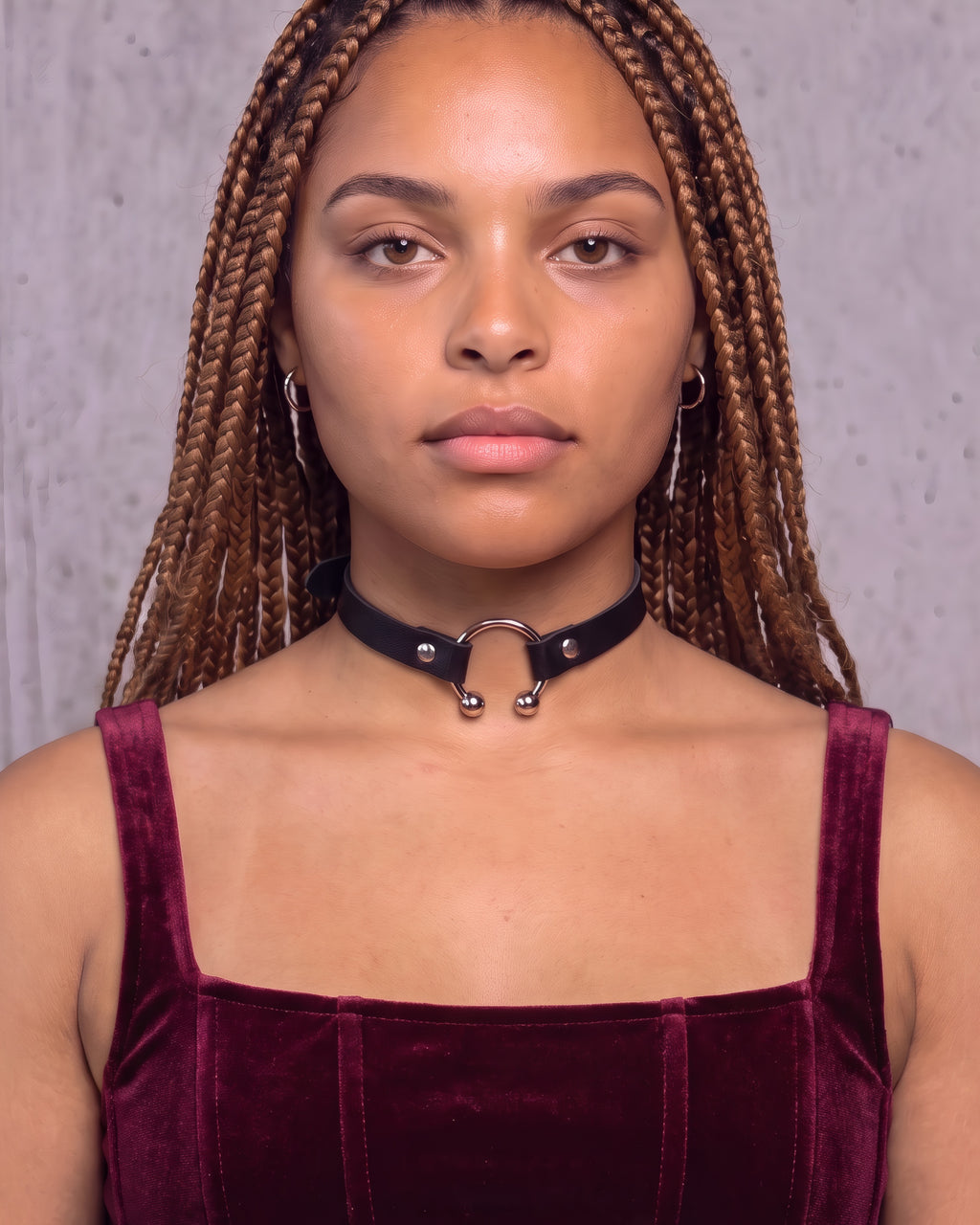 Collier ras-de-cou Salomé en cuir vegan noir à anneau fer à cheval argenté, porté de face avec un top en velours bordeaux