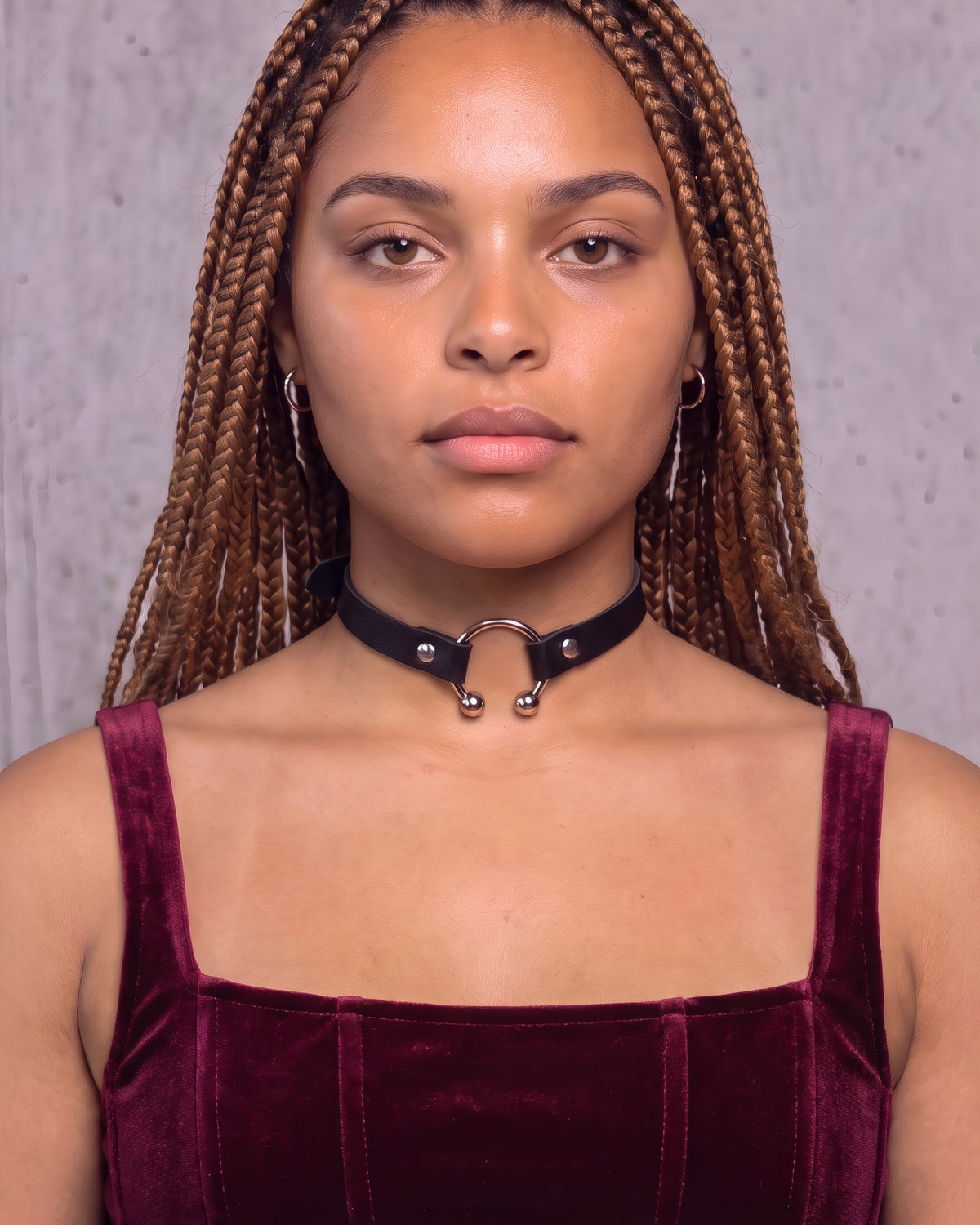 Collier ras-de-cou Salomé en cuir vegan noir à anneau fer à cheval argenté, porté de face avec un top en velours bordeaux